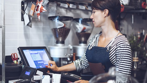 serveuse tapant sur sa caisse enregistreuse
